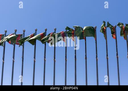 Asjchabad, Turkmenistan - 1 giugno 2019: Bandiere nella città di marmo e bianco di Asjchabad in Turkmenistan. Foto Stock