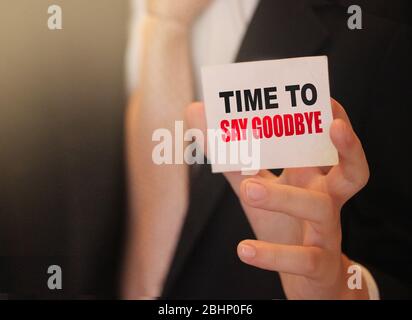 È il momento di dire addio parole su una carta in mano di uomo d'affari. Concetto di risoluzione del contratto commerciale Foto Stock