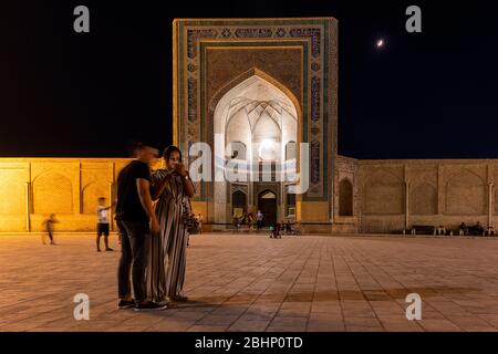 Bukhara, Uzbekistan - 7 giugno 2019: Serata con persone sulla piazza della Moschea di Kalan nella città vecchia di Bukhara in Uzbekistan. Foto Stock