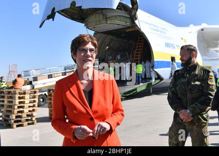 27 aprile 2020, Sassonia, Schkeuditz: Annegret Kramp-Karmenbauer (CDU), Ministro federale della difesa, ispeziona un trasporto delle forze armate tedesche con maschere protettive all'aeroporto di Lipsia/Halle. Le maschere erano precedentemente atterrate all'aeroporto con il più grande velivolo da carico del mondo, l'Antonov 225. Secondo la Bundeswehr, l'"ascensore aereo" proveniente dalla Cina consiste in un totale di tre voli merci. Circa 25 milioni di maschere protettive saranno volate in Germania. Il trasporto fa parte dell'assistenza amministrativa della Bundeswehr nella crisi di Corona. Foto: Hendrik Schmidt/dpa-Zentralbild/dpa Foto Stock