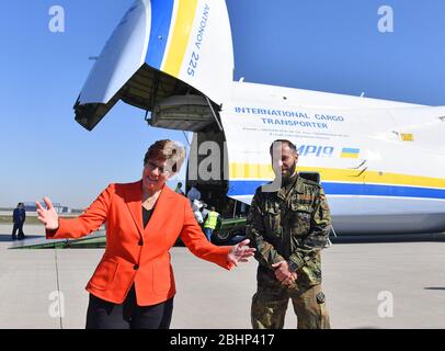 27 aprile 2020, Sassonia, Schkeuditz: Annegret Kramp-Karmenbauer (CDU), Ministro federale della difesa, ispeziona un trasporto delle forze armate tedesche con maschere protettive all'aeroporto di Lipsia/Halle. Le maschere erano precedentemente atterrate all'aeroporto con il più grande velivolo da carico del mondo, l'Antonov 225. Secondo la Bundeswehr, l'"ascensore aereo" proveniente dalla Cina consiste in un totale di tre voli merci. Circa 25 milioni di maschere protettive saranno volate in Germania. Il trasporto fa parte dell'assistenza amministrativa della Bundeswehr nella crisi di Corona. Foto: Hendrik Schmidt/dpa-Zentralbild/dpa Foto Stock