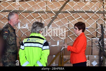 27 aprile 2020, Sassonia, Schkeuditz: Annegret Kramp-KARrenbauer (CDU, r.), Ministro federale della difesa, parla con i soldati e il personale aeroportuale all'aeroporto di Lipsia/Halle in un Antonov di fronte a un trasporto Bundeswehr con maschere protettive. Le maschere erano precedentemente atterrate all'aeroporto con il più grande velivolo da carico del mondo, l'Antonov 225. Secondo la Bundeswehr, l'"ascensore aereo" proveniente dalla Cina consiste in un totale di tre voli merci. Circa 25 milioni di maschere protettive saranno volate in Germania. Il trasporto fa parte dell'assistenza amministrativa della Bundeswehr nella crisi di Corona. Foto: Gallina Foto Stock