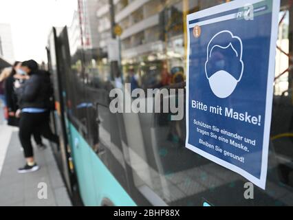 27 aprile 2020, Hessen, Francoforte sul meno: Un poster con l'iscrizione 'si prega di indossare una maschera! Proteggersi e indossare una maschera. Rimanere in salute!" Viene visualizzato alla fermata Konstabler Wache su un autobus del Rhein-Main-Verkehrsverbund. Foto: Arne Dedert/dpa Foto Stock