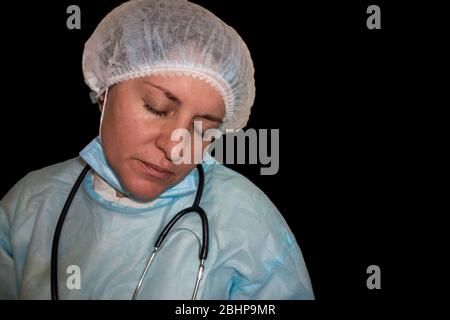 Immagine isolata del sonno di un medico o di un infermiere. Coronavirus COVID-19 pandemico. Donna stanca ed esausta in uniforme dorme in ospedale o in clinica dopo duro Foto Stock