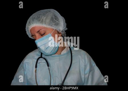 Immagine isolata del sonno di un medico o di un infermiere. Coronavirus COVID-19 pandemico. Donna stanca ed esausta in uniforme dorme in ospedale o in clinica dopo duro Foto Stock