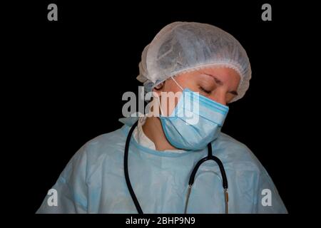 Immagine isolata del sonno di un medico o di un infermiere. Coronavirus COVID-19 pandemico. Donna stanca ed esausta in uniforme dorme in ospedale o in clinica dopo duro Foto Stock