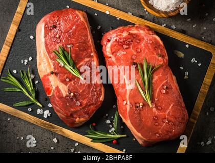 Bistecca di manzo fresca su tavolo nero. Foto Stock