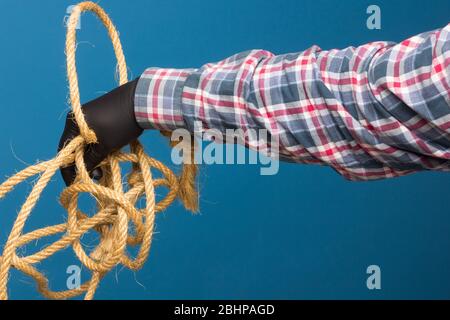 Corda gialla nella mano esperta di un adulto con protezione. Corda spessa per legare oggetti. Foto Stock