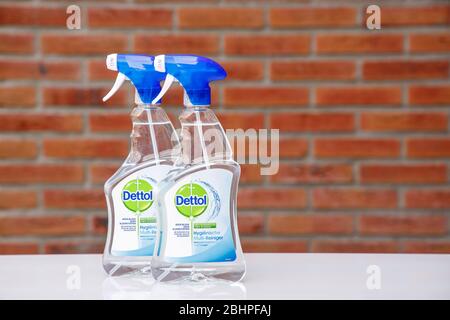 Dettol multi usi detergente antibatterico per superfici su tavolo di vetro bianco contro sfondo muro di mattoni sfocati. Concetto di prevenzione del coronavirus. Foto Stock