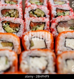 Primo piano di sushi roll con salmone, avocado e formaggio. Ristorante di cucina Giapponese. Foto Stock