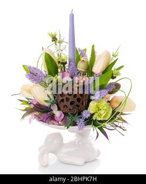 Composizione decorativa pasquale. Un coniglietto contiene una composizione di fiori. Foto Stock