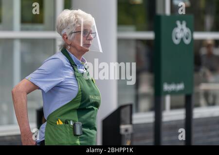 Il dipendente Waitrose & Partners indossa uno scudo facciale fuori dal gigante del supermercato. Foto Stock