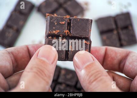 Uomo che tiene in mano cioccolato fondente fatto in casa. Primo piano. Foto Stock
