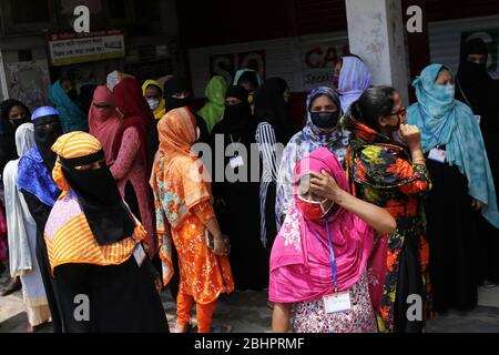 Dhaka, Bangladesh. 27 aprile 2020. I lavoratori dell'abbigliamento si riuniscono per unirsi al loro lavoro di fronte a una fabbrica vicino all'area di Banani durante la chiusura a terra a livello nazionale a Dhaka. Credit: MD Mehedi Hasan/ZUMA Wire/Alamy Live News Foto Stock