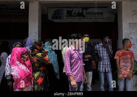 Dhaka, Bangladesh. 27 aprile 2020. I lavoratori dell'abbigliamento si riuniscono per unirsi al loro lavoro di fronte a una fabbrica vicino all'area di Banani durante la chiusura a terra a livello nazionale a Dhaka. Credit: MD Mehedi Hasan/ZUMA Wire/Alamy Live News Foto Stock