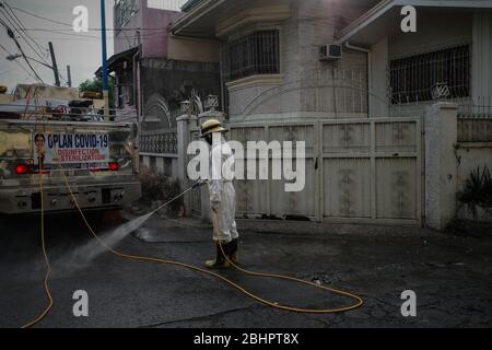 Luzon, Filippine. 27 aprile 2020. I volontari del fuoco spruzzano disinfettante su una strada a Mandaluyong City il lunedì 27 aprile 2020. La città continua la sua disinfezione regolare di strade e vicoli per frenare la diffusione del COVID-19. L'Ufficio di correzioni ha confermato 27 altri detenuti dell'Istituto Correctional per le Donne nella città testato positivo per il coronavirus. (Foto di Larry Monserate Piojo/Sipa USA) Credit: Sipa USA/Alamy Live News Foto Stock