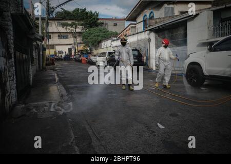 Luzon, Filippine. 27 aprile 2020. I volontari del fuoco spruzzano disinfettante su una strada a Mandaluyong City il lunedì 27 aprile 2020. La città continua la sua disinfezione regolare di strade e vicoli per frenare la diffusione del COVID-19. L'Ufficio di correzioni ha confermato 27 altri detenuti dell'Istituto Correctional per le Donne nella città testato positivo per il coronavirus. (Foto di Larry Monserate Piojo/Sipa USA) Credit: Sipa USA/Alamy Live News Foto Stock