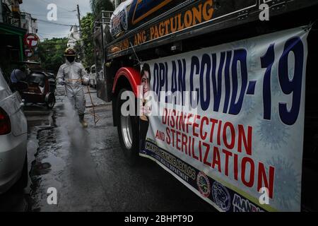 Luzon, Filippine. 27 aprile 2020. I volontari del fuoco spruzzano disinfettante su una strada a Mandaluyong City il lunedì 27 aprile 2020. La città continua la sua disinfezione regolare di strade e vicoli per frenare la diffusione del COVID-19. L'Ufficio di correzioni ha confermato 27 altri detenuti dell'Istituto Correctional per le Donne nella città testato positivo per il coronavirus. (Foto di Larry Monserate Piojo/Sipa USA) Credit: Sipa USA/Alamy Live News Foto Stock