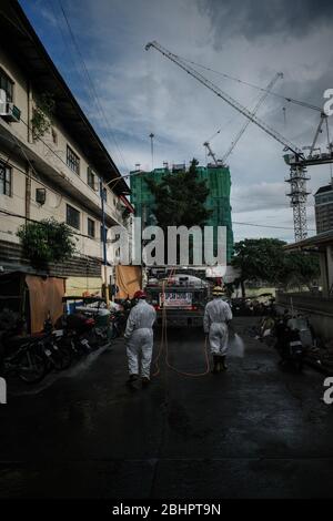 Luzon, Filippine. 27 aprile 2020. I volontari del fuoco spruzzano disinfettante su una strada a Mandaluyong City il lunedì 27 aprile 2020. La città continua la sua disinfezione regolare di strade e vicoli per frenare la diffusione del COVID-19. L'Ufficio di correzioni ha confermato 27 altri detenuti dell'Istituto Correctional per le Donne nella città testato positivo per il coronavirus. (Foto di Larry Monserate Piojo/Sipa USA) Credit: Sipa USA/Alamy Live News Foto Stock