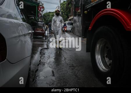 Luzon, Filippine. 27 aprile 2020. I volontari del fuoco spruzzano disinfettante su una strada a Mandaluyong City il lunedì 27 aprile 2020. La città continua la sua disinfezione regolare di strade e vicoli per frenare la diffusione del COVID-19. L'Ufficio di correzioni ha confermato 27 altri detenuti dell'Istituto Correctional per le Donne nella città testato positivo per il coronavirus. (Foto di Larry Monserate Piojo/Sipa USA) Credit: Sipa USA/Alamy Live News Foto Stock