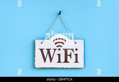 L'iscrizione Wi-Fi sul piatto in stile vintage. Sfondo blu. Primo piano. Disposizione piatta. Foto Stock