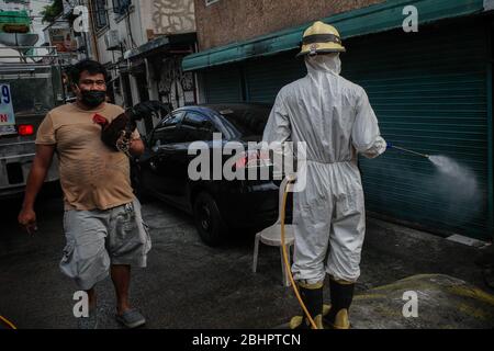 Luzon, Filippine. 27 aprile 2020. I volontari del fuoco spruzzano disinfettante su una strada a Mandaluyong City il lunedì 27 aprile 2020. La città continua la sua disinfezione regolare di strade e vicoli per frenare la diffusione del COVID-19. L'Ufficio di correzioni ha confermato 27 altri detenuti dell'Istituto Correctional per le Donne nella città testato positivo per il coronavirus. (Foto di Larry Monserate Piojo/Sipa USA) Credit: Sipa USA/Alamy Live News Foto Stock