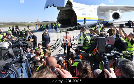 27 aprile 2020, Sassonia, Schkeuditz: Annegret Kramp-KARrenbauer (CDU), il ministro federale della difesa, fa una dichiarazione all'aeroporto di Lipsia/Halle circondato da giornalisti e dipendenti degli aeroporti che si stanno avvicinando troppo. Kramp-KARrenbauer ha assistito all'atterraggio del più grande aereo da carico del mondo, l'Antonov 225, con maschere protettive all'aeroporto. Secondo la Bundeswehr, l'"ascensore aereo" proveniente dalla Cina consiste in un totale di tre voli merci. Circa 25 milioni di maschere protettive saranno volate in Germania. Il trasporto fa parte dell'assistenza amministrativa della Bundeswehr presso il Cor Foto Stock