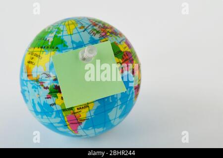 Pianeta Terra con nota adesiva vuota su sfondo bianco - concetto di ecologia e conservazione ambientale Foto Stock