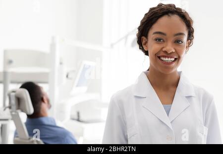 Ritratto di una donna africana allegra dentista sopra gabinetto dentista Foto Stock