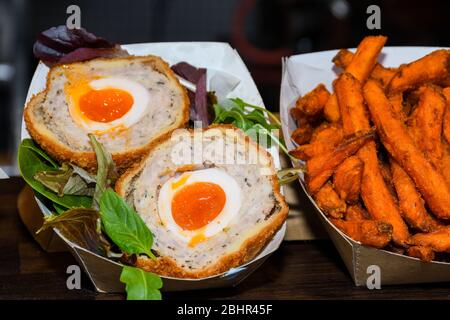 Un uovo di scotch è costituito da un uovo intero morbido o sodo-bollito avvolto in carne di salsiccia, rivestito in briciole di pane e cotto o fritto profondo. Foto Stock