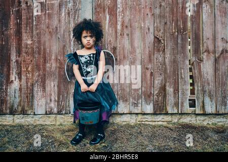 Una ragazza in un costume di Halloween streghe con un ragno dipinto sul suo viso in costume pronto per trucco o trattamento. Foto Stock