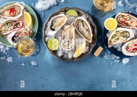 Ostriche con vari condimenti, farcite dall'alto con vino, limone e lime, pepe, cipolla, con un posto per il testo Foto Stock