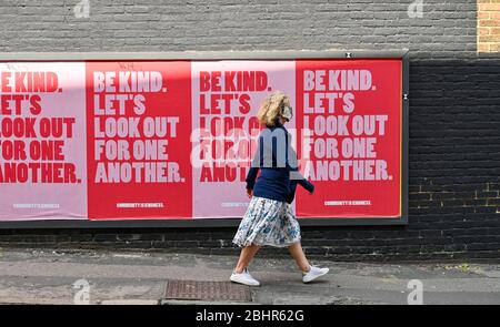 Brighton UK 27 Aprile 2020 - UNO shopper passa alcuni poster 'Be Kind' nella zona di London Road di Brighton mentre le restrizioni di blocco continuano durante la crisi pandemica Coronavirus COVID-19 . Credit: Simon Dack / Alamy Live News Foto Stock