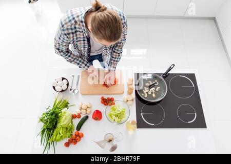 Top sopra alto angolo vista ritratto del suo bel ragazzo biondo attraente focalizzato fare fresco delizioso cucina julienne domestico corsi culinari in Foto Stock