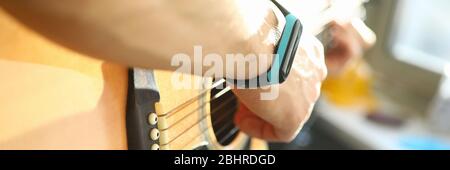 Primo piano, mani maschili che suonano la chitarra vicino alla finestra Foto Stock