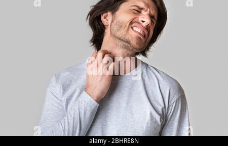 Eruzione cutanea allergica. Uomo che soffre di prurito sulla pelle e graffiare la gola Foto Stock