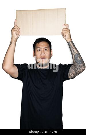 Lavoratore asiatico barbuto uomini vestiti in tee nere è in attesa di cartone in bianco background.The concetto di protesta, attenzione, richiesta. Inserire per il testo o. Foto Stock
