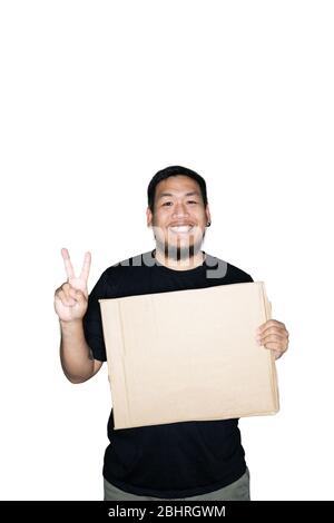 Lavoratore degli uomini asiatici bearded vestito in tee nere sta tenendo cartone e mostrando il segno di vittoria in sfondo bianco.il concetto di protesta, attenzione, re Foto Stock