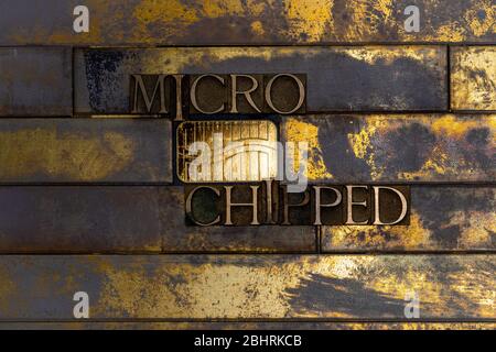 Foto di autentiche lettere typeset formanti Micro chip di rivestimento del testo scheggiato su vintage testurizzato grunge rame e oro sfondo Foto Stock