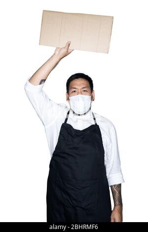 Cameriere degli uomini asiatici bearded, chef vestito in grembiule nero con maschera medica sta tenendo il cartone in sfondo bianco.il concetto di protesta, attenzione, re Foto Stock