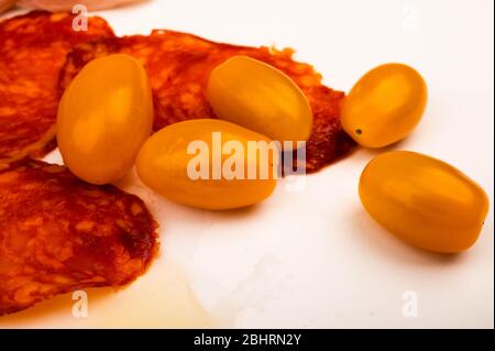 Fette di salsiccia e pancetta e pomodori su sfondo bianco. Primo piano Foto Stock