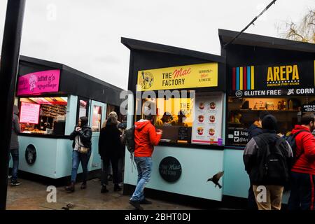 Londra, UK, 25 gennaio 2020: Uomo che ordina cibo a Camden Market, Londra. Iniziato con 16 bancarelle nel 1974, Camden Market è uno dei più trafficati reta Foto Stock