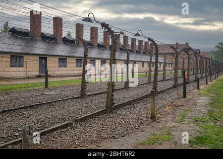 Edifici del campo di concentramento Auschwitz circondato bij filo Foto Stock