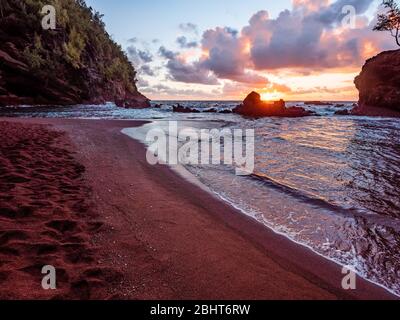 Sole che sorge sulla spiaggia di Red Sand (Kaihalulu Beach) a Maui. Foto Stock