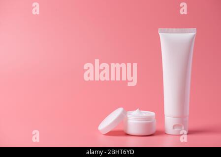 Pubblicità fatto in casa concetto creativo minimo. Foto di una provetta di plastica con detergente e vaso rotondo aperto con coperchio isolato su sfondo pastello Foto Stock