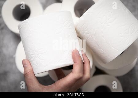La mano femminile prende un rotolo di carta igienica per il suo uso previsto. Foto Stock