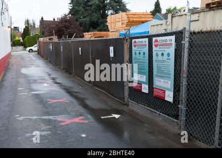 I marcatori indicano intervalli di distanza sociale di 6 piedi appropriati in un punto di controllo di screening COVID-19 in un cantiere di costruzione a Seattle Ovest, mentre la costruzione riprende lunedì 27 aprile 2020. Per riprendere i progetti di costruzione residenziale e commerciale a basso rischio, è necessario rispettare le pratiche di sicurezza specifiche del cantiere COVID-19. Foto Stock