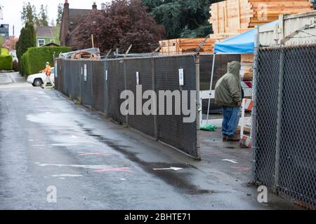 Un lavoratore arriva a un punto di controllo di screening in un cantiere di costruzione a Seattle Ovest come la costruzione riprende Lunedi, 27 aprile 2020. Per riprendere i progetti di costruzione residenziale e commerciale a basso rischio, è necessario rispettare le pratiche di sicurezza specifiche del cantiere COVID-19. Foto Stock