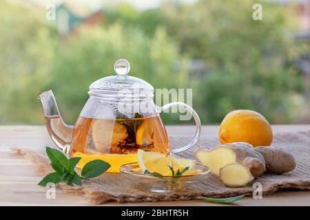 STILL LIFE, immunità e concetto di assistenza sanitaria. Tè allo zenzero, limone e menta su un tavolo di legno. Messa a fuoco selettiva. Foto Stock