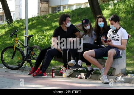 Belgrado, Serbia. 27 aprile 2020. Un gruppo di giovani che indossano maschere protettive per il viso godono di una giornata calda e soleggiata al parco, tra il coronavirus in corso COVID-19 pandemic. I cittadini serbi stanno lentamente tornando alla vita normale, poiché le autorità stanno allentando alcune delle misure adottate per limitare la diffusione del coronavirus SARS-cov-2 che causa la malattia di COVID-19. Credit: Koca Sulejmanovic/Alamy Live News Foto Stock